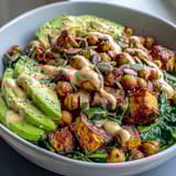 Savory garlicky spinach and creamy avocado slices topped with smoky chipotle tahini dressing over a wholesome grain bowl.