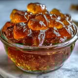 Bright, floral dandelion jelly infused with zesty lemon and honey, served alongside fresh scones and butter.