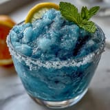 Refreshing Blue Raspberry Lemonade Slushie, blended smooth with tangy lemon and sweet syrup.