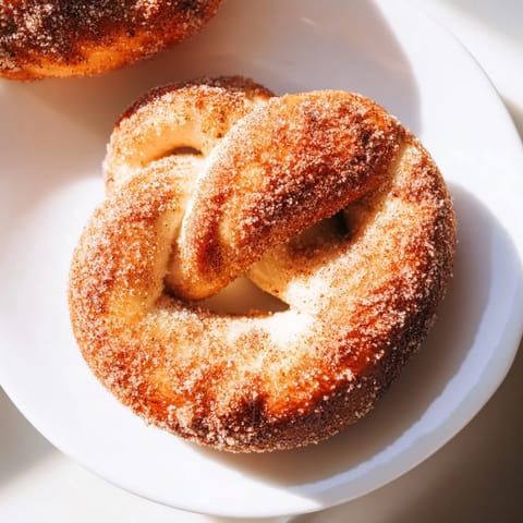 Soft, glistening cinnamon sugar pretzels, perfect for dipping in cream cheese or sharing with friends.