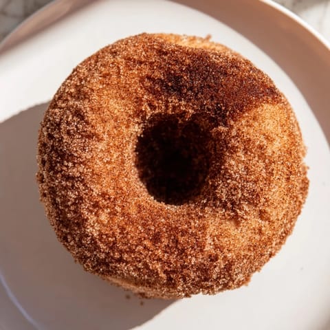 A close-up of freshly baked apple cider donuts, perfect alongside a cup of hot apple cider.