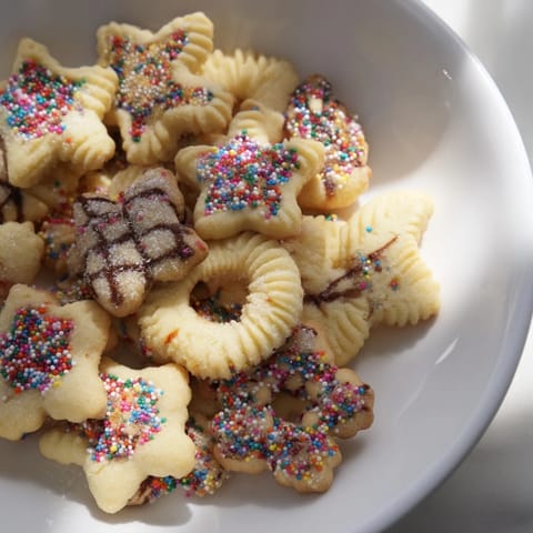 Festive Spritz Cookies: Buttery, tender cookies with colorful sprinkles, perfect for sharing.