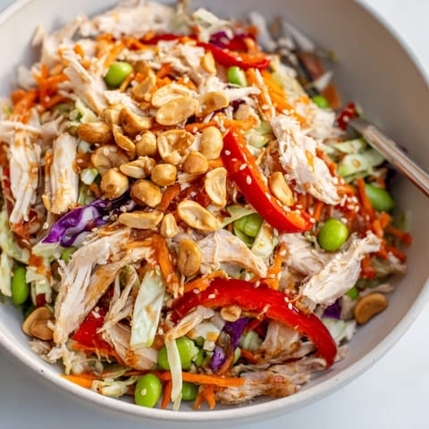 Edamame Crunch Chicken Salad served in a bowl topped with sliced almonds and fresh green onions.  