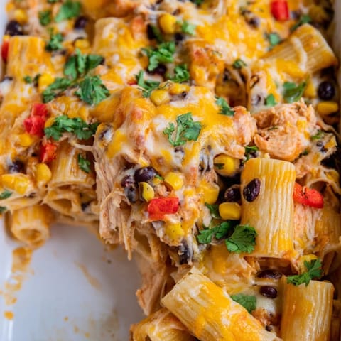 A steaming dish of Chicken Burrito Pasta Bake with shredded chicken, salsa, and Monterey Jack cheese, perfect for a family dinner.
