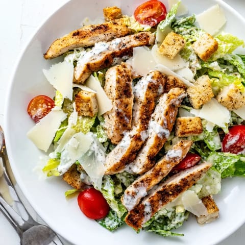 Grilled chicken strips atop crisp romaine lettuce in this refreshing Yogurt Caesar Grilled Chicken Salad.  