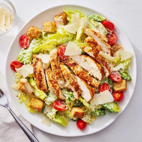 A creamy Greek yogurt Caesar dressing coats tender grilled chicken and crunchy croutons in this vibrant salad.  