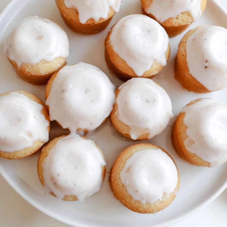 Freshly baked muffin tin donuts, topped with sweet, shiny glaze waiting to be enjoyed.