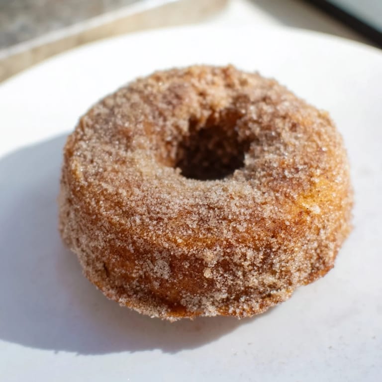 Homemade apple cider donuts, fluffy and aromatic, offering a delicious taste of fall flavors.
