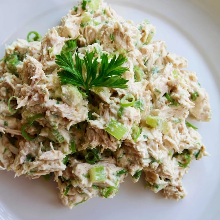 A delicious scoop of Spicy Zesty Tuna Salad sits on toasted sourdough bread, ready to serve as a protein-packed, dairy-free sandwich or wrap.